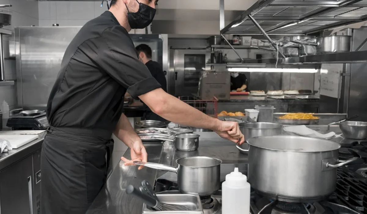 Cocinero trabajando bajo la campana de extracción de una cocina profesional